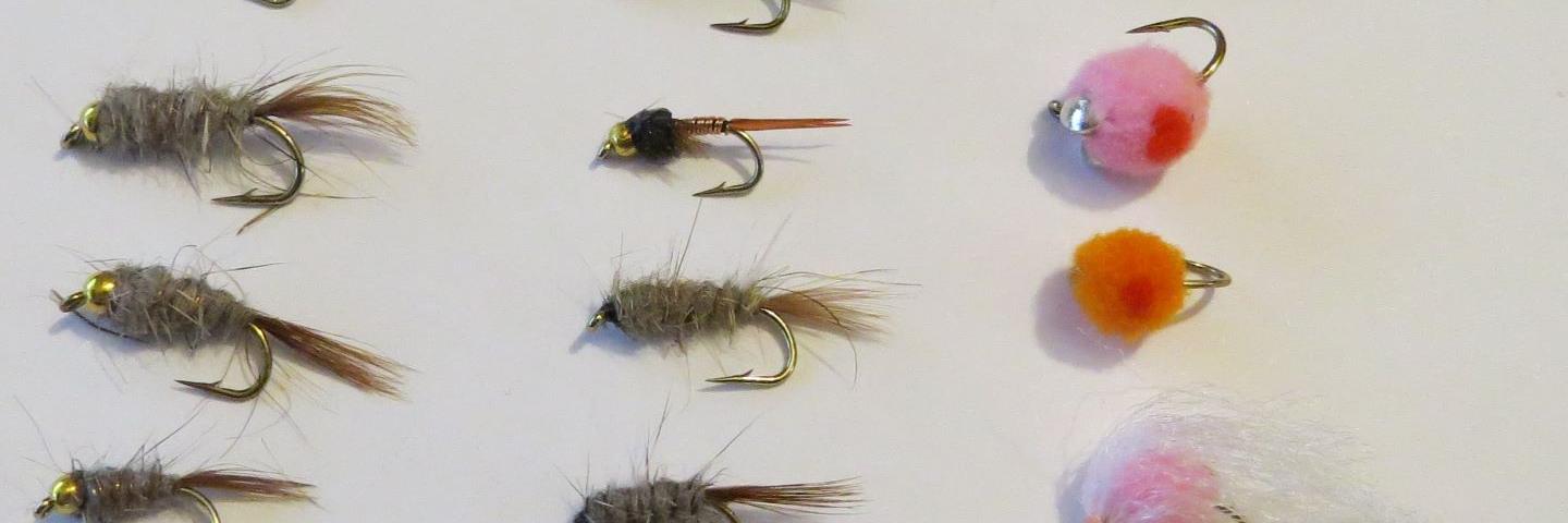 A winter nymphing fly pack arranged on a pale surface